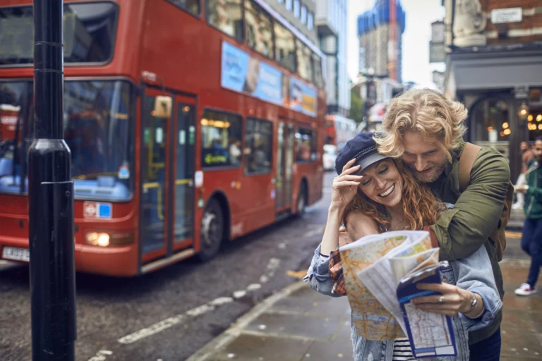 A couple with a map in front of a bus making a city trip