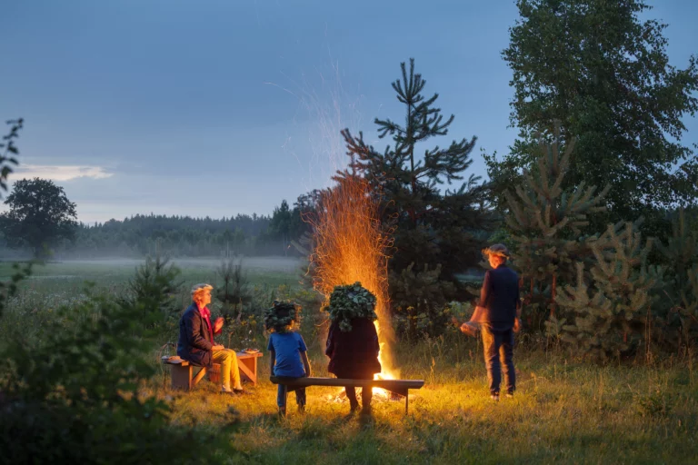 Family at a bonfire near a lake in Latvia